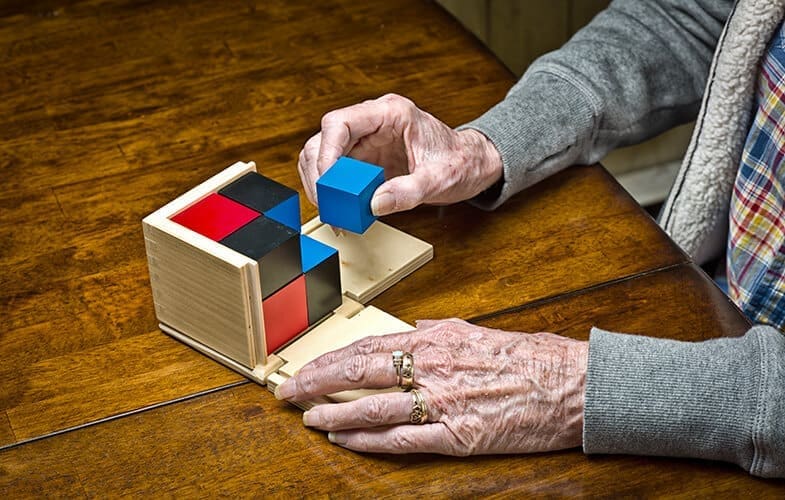 Senior-Woman-Dementia-Patient-Works-on-a-Puzzle.-466331288_5212x3468