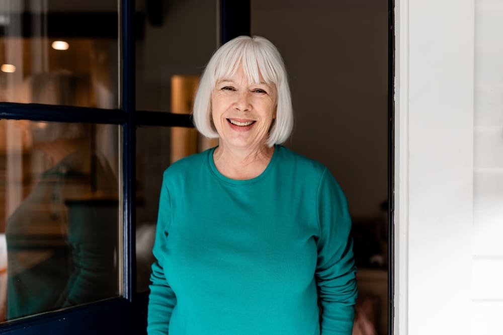 Smiling,Senior,Woman,Greeting,Guest,,Retirement,Home,Doorstep