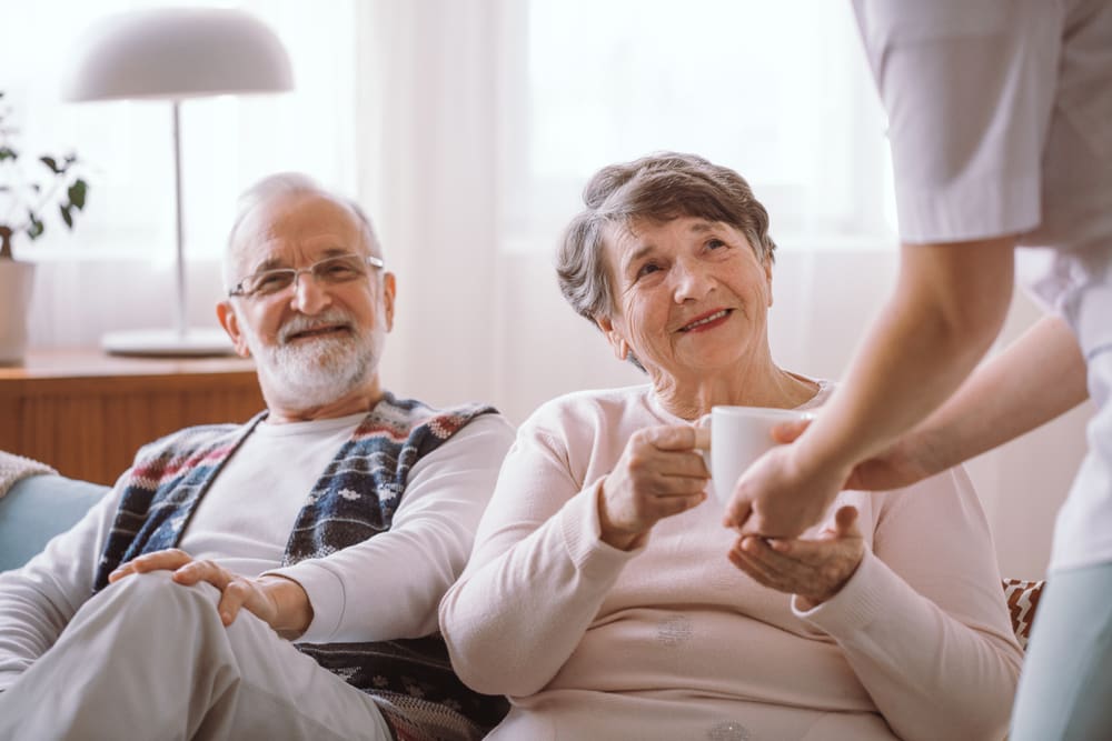 Happy,Grandmother,Taking,A,Cup,Of,Tea,From,Her,Caregiver